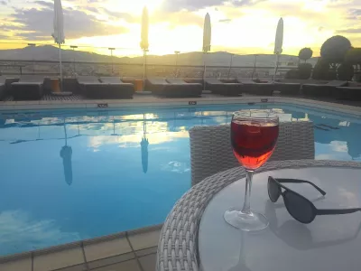 Valor monetário de pontos de hotel - quanto pontos de hotel valem : Desfrutar de uma bebida de uma piscina no terraço do hotel em Atenas