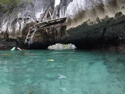 Mini Udhëzues Udhëtimi: Një ditë aventure në Coron, Palawan : Hyrja në lagunën e fshehur, e përshtatur nga shkëmbinjtë gëlqerorë dhe bimësia e harlisur.