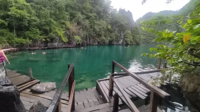 Mini Udhëzues Udhëtimi: Një ditë aventure në Coron, Palawan : Ujërat e pastër kristal të Liqenit Kayangan, me një vendkalim prej druri që çon në një këndvështrim mahnitës.