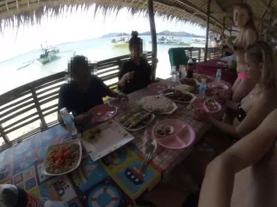 Mini Udhëzues Udhëtimi: Një ditë aventure në Coron, Palawan : Festa jonë e ushqimit të detit të shtruar në një kasolle tradicionale, me peizazhin e bukur të plazhit në sfond.